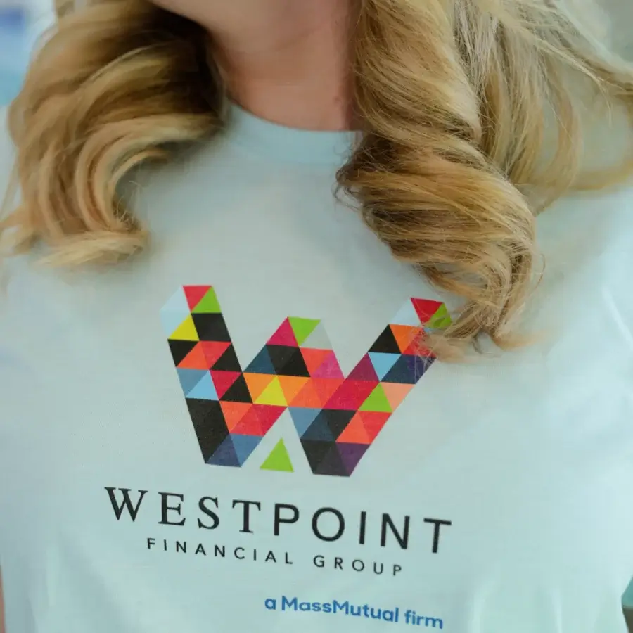 Close-up of a person wearing a light blue shirt with a colorful geometric "W" logo and text reading "WestPoint Financial Group, a MassMutual firm.