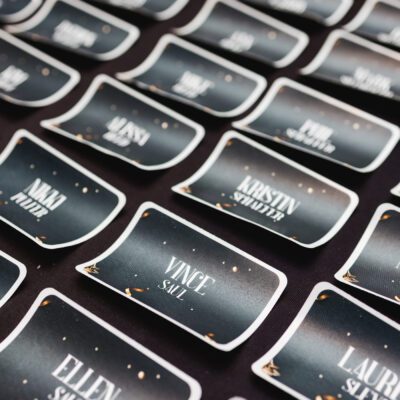Rows of black name tags with white text are arranged on a dark surface, each displaying different names and surnames.